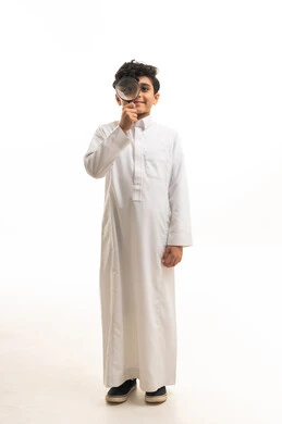 طفل سعودي يرتدي الثوب التقليدي ويمسك عدسة مكبرة للبحث