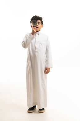 طفل سعودي مع عدسة مكبرة على خلفية بيضاء