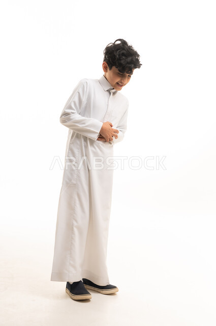 ولد سعودي بالثوب الأبيض التقليدي يضحك في الاستوديو