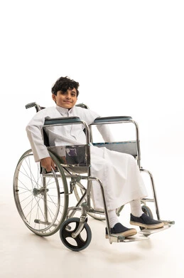 Saudi Boy in Wheelchair Wearing Traditional Thobe