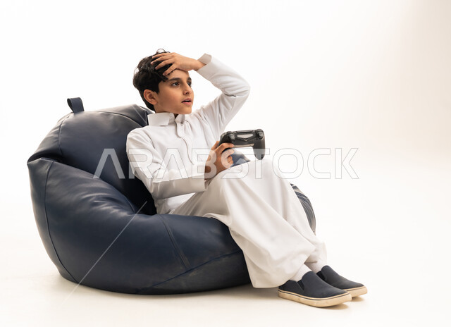 طفل سعودي يلعب ألعاب الفيديو بالثوب التقليدي