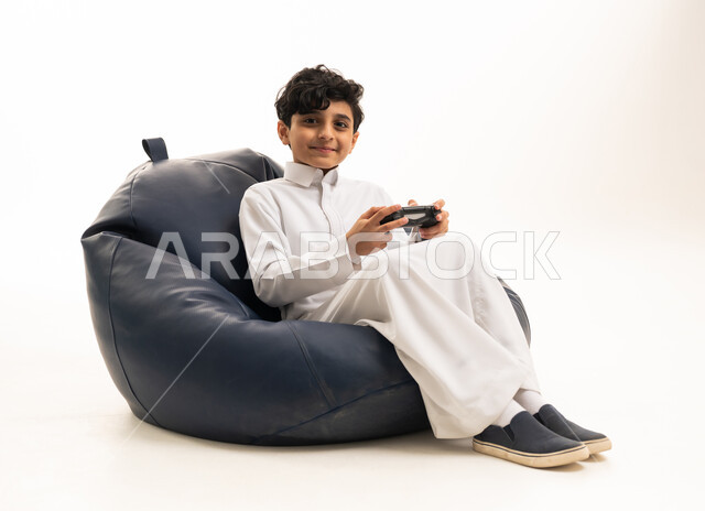 طفل سعودي بالثوب الأبيض يلعب ألعاب الفيديو