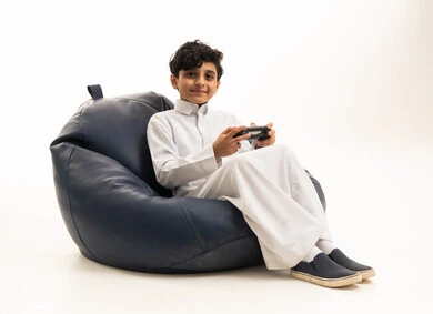 طفل سعودي بالثوب الأبيض يلعب ألعاب الفيديو