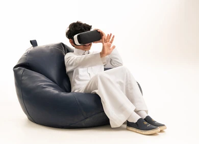 Saudi Boy Using VR Goggles Wearing White Thobe on Beanbag