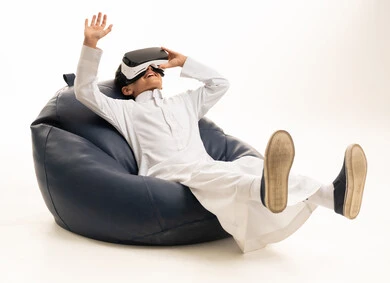 طفل سعودي بالثوب يستخدم نظارات الواقع الافتراضي