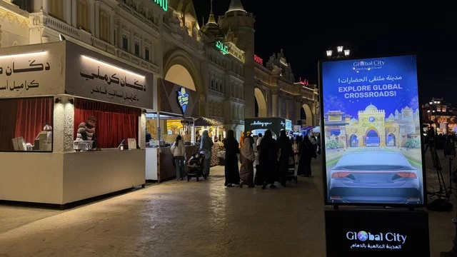 Global Village Dubai Night Scene with Kiosks and Signage