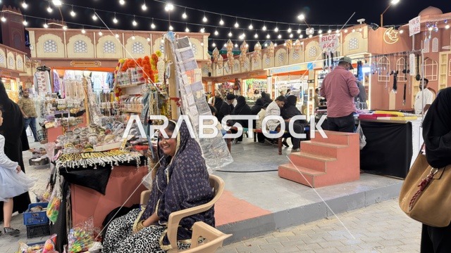 سوق شعبي ليلي مع بائعة ومتسوقين وإضاءة زينة