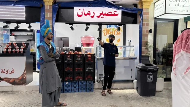 بائع عصير ورجل بزي فلكلوري في سوق خارجي