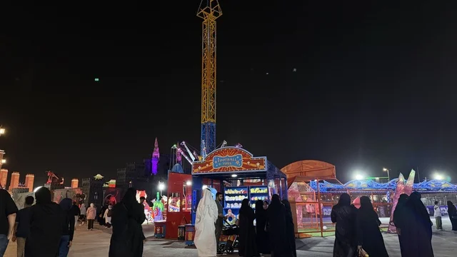 مدينة ملاهي مضيئة في السعودية ليلاً