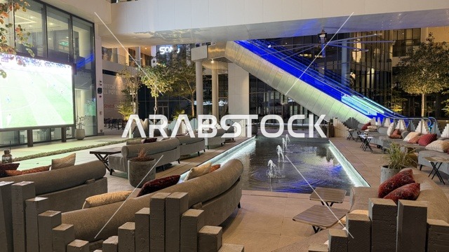 منطقة جلوس خارجية في مول مع شاشة عرض ونافورة