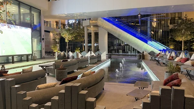 منطقة جلوس خارجية في مول مع شاشة عرض ونافورة