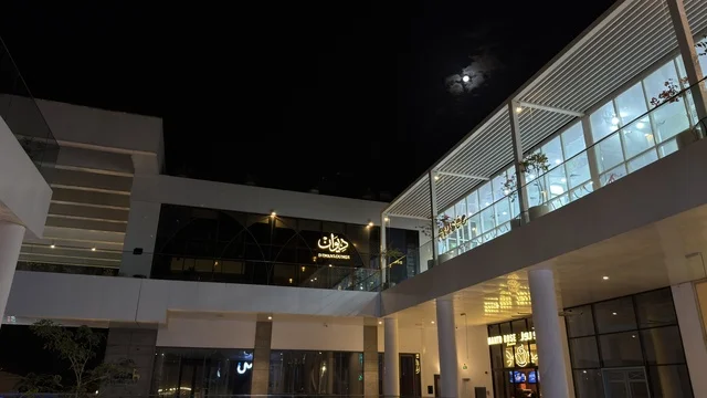 Modern Commercial Plaza Building at Night with Moon