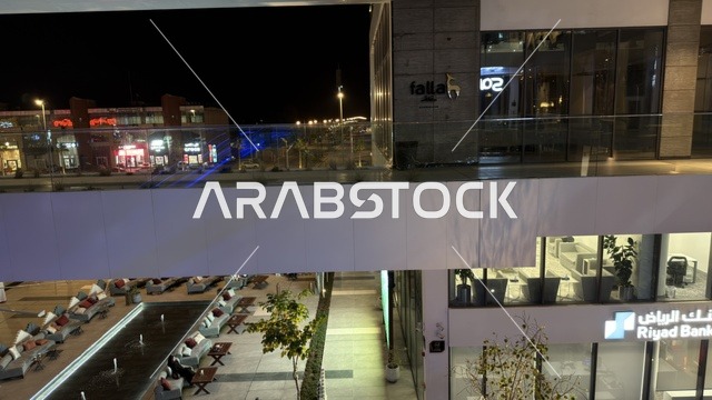 ساحة تجارية حديثة في الرياض مع بنك الرياض ليلاً