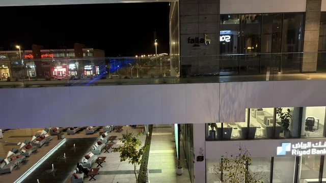 ساحة تجارية حديثة في الرياض مع بنك الرياض ليلاً