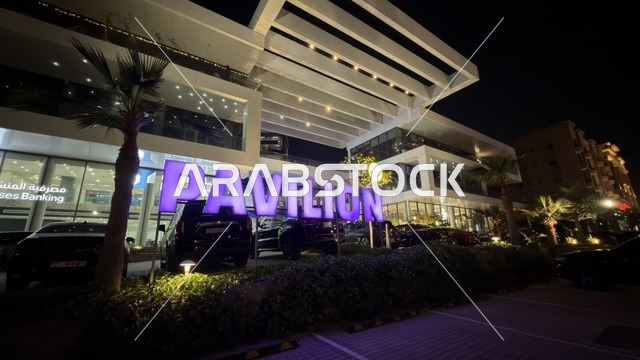 الواجهة الخارجية لمبنى بافيليون مع لوحة نيون ليلاً