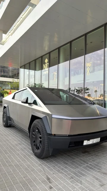 سيارة تسلا سايبرتراك أمام مبنى حديث في دبي