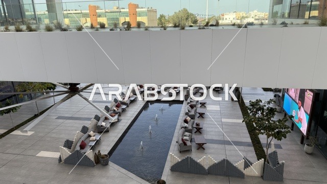 منطقة جلسة خارجية حديثة مع نافورة مياه وترتيبات كنب