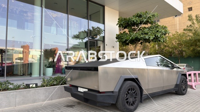 Tesla Cybertruck Parked in Front of Modern Glass Building