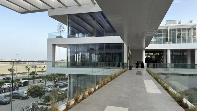 مجمع تجاري حديث بواجهات زجاجية وتصميم معماري