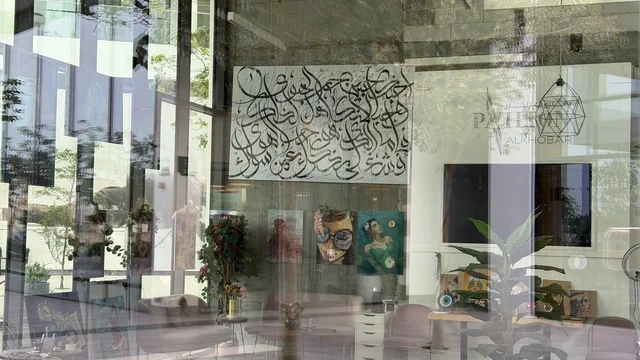 معرض فني حديث مع لوحات خط عربي وديكور مكتبي