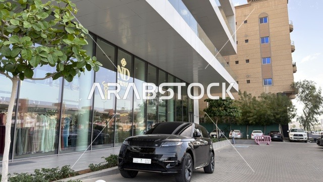 سيارة دفع رباعي سوداء أمام مبنى تجاري حديث