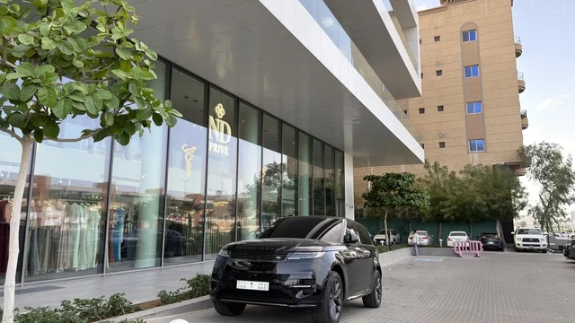 سيارة دفع رباعي سوداء أمام مبنى تجاري حديث