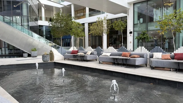 منطقة جلوس خارجية حديثة مع نافورة في ساحة