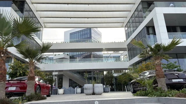 ساحة مكاتب تجارية حديثة مع سيارات رياضية فاخرة