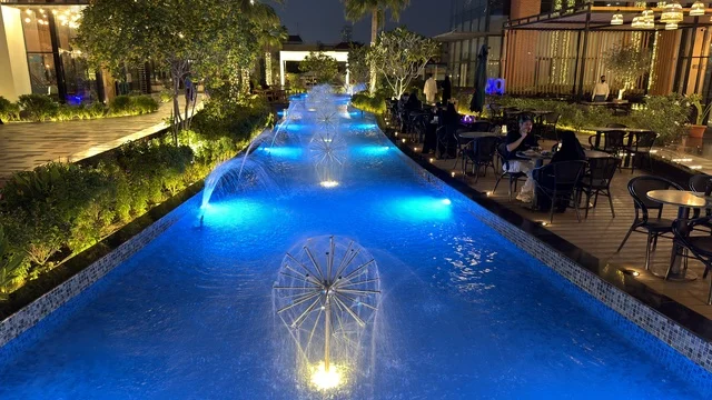 مطعم بجلسات خارجية مع نافورة مياه مضيئة باللون الأزرق