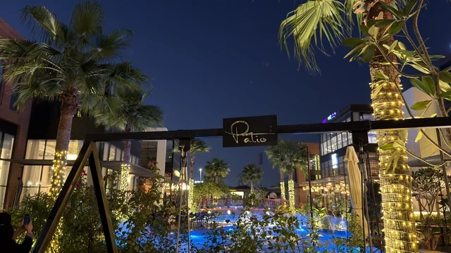 منطقة جلسات الباتيو الخارجية ليلاً مع النخيل المضيء