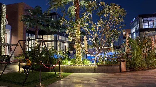 طفل على أرجوحة في ساحة تسوق ليلية