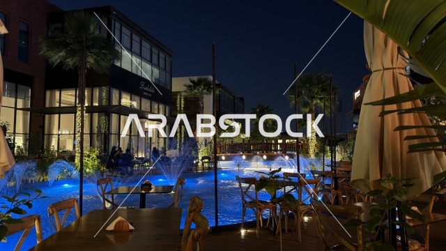 Outdoor Restaurant with Blue Lit Fountains at Night