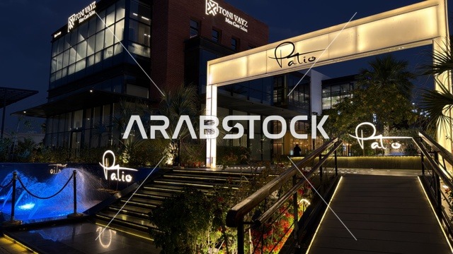 مدخل مبنى مطعم باتيو وصالون توني يزي مع إضاءة ليلية