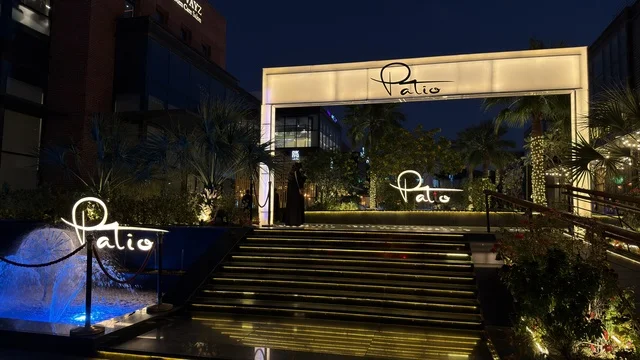 مدخل باتيو ليلاً مع سلالم مضيئة ونافورة زرقاء