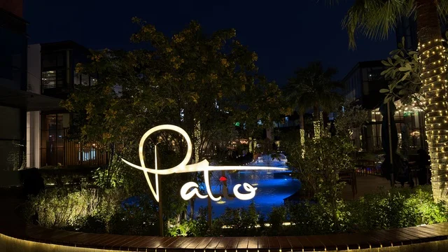 لوحة مطعم باتو المضيئة مع نافورة في الليل