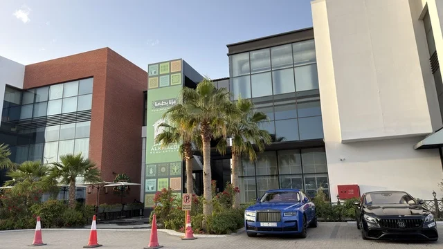 مبنى مكاتب حديث مع سيارة زرقاء فاخرة في الخارج