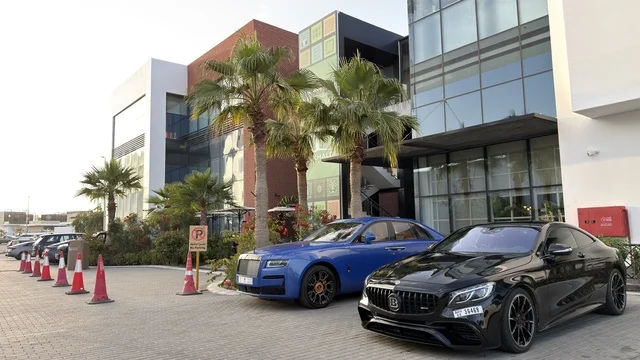 سيارات فاخرة متوقفة أمام مبنى تجاري حديث