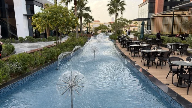 نافورة مياه حديثة وجلسات مقاهي خارجية في ساحة حضرية