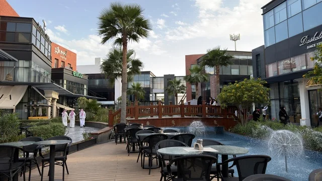 مجمع تجاري خارجي حديث مع أشجار نخيل ونوافير