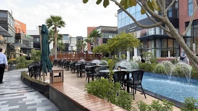 تراس مطعم خارجي وساحة حضرية حديثة في مجمع تجاري نهارا