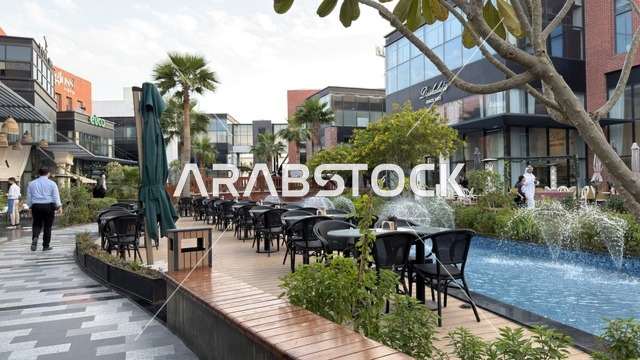 منطقة طعام خارجية في ساحة حضرية حديثة مع نافورة