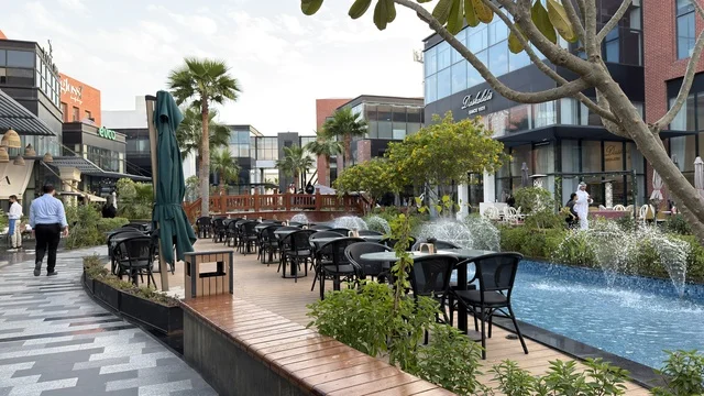 منطقة طعام خارجية في ساحة حضرية حديثة مع نافورة