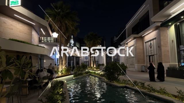 ساحة خارجية حديثة ليلاً مع مسطح مائي وإضاءة