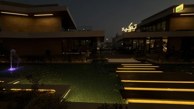 ساحة تجارية حديثة مع ممرات مضاءة ليلاً