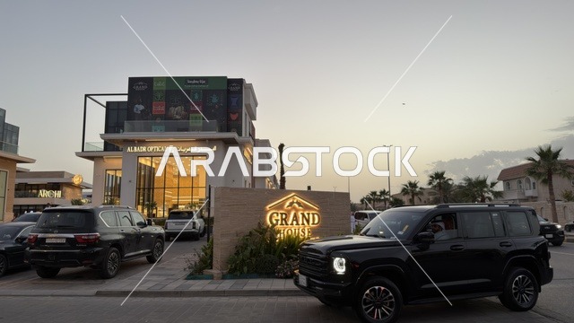مجمع جراند هاوس التجاري والسيارات الفاخرة وقت الغروب