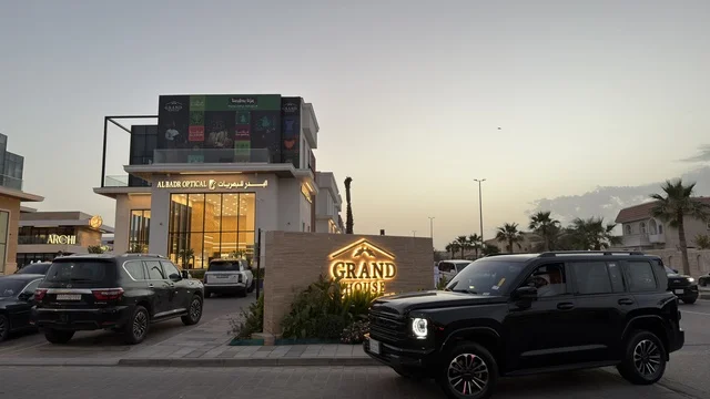 مجمع جراند هاوس التجاري والسيارات الفاخرة وقت الغروب