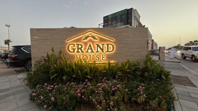 لوحة جراند هاوس المضيئة في بيئة حضرية وقت الغسق