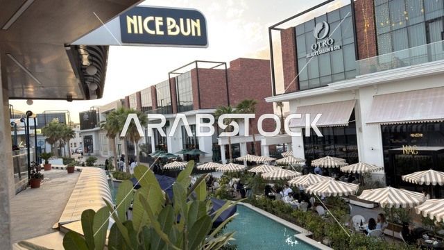 مجمع تسوق خارجي حديث وجلسات مطاعم وقت الغروب