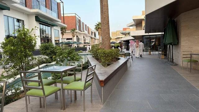 Modern Outdoor Mall Plaza with Cafe Seating and Palms