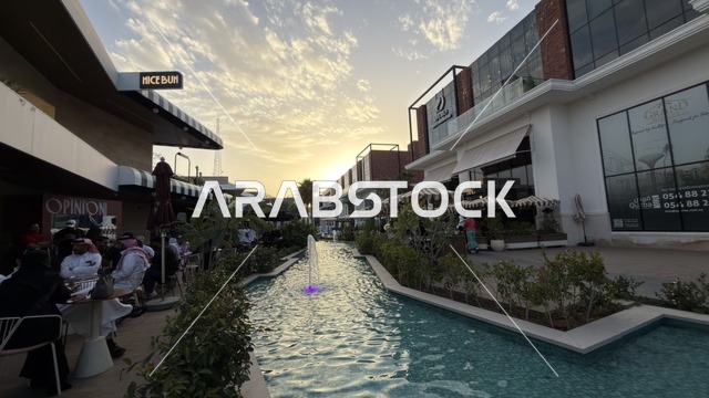 مجمع تجاري سعودي خارجي مع نافورة وقت الغروب